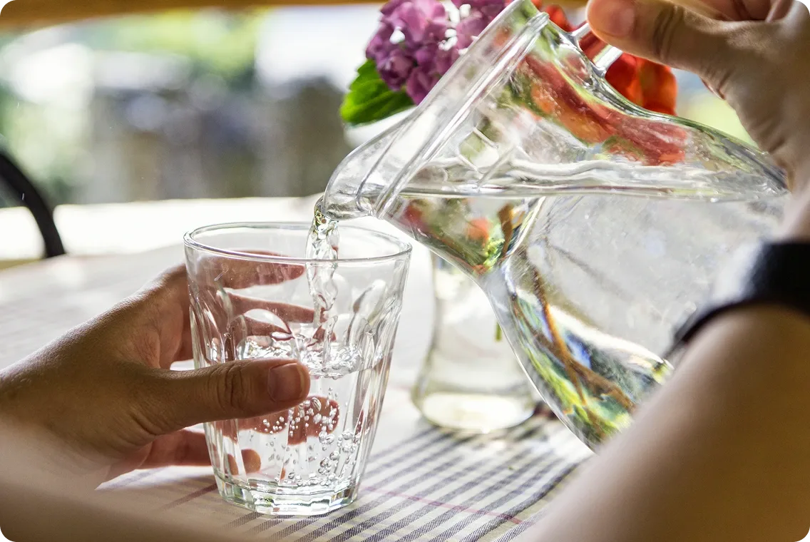 A glass of water being poured