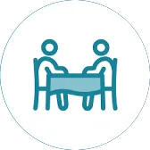 Icon of two people sharing a meal at a table.